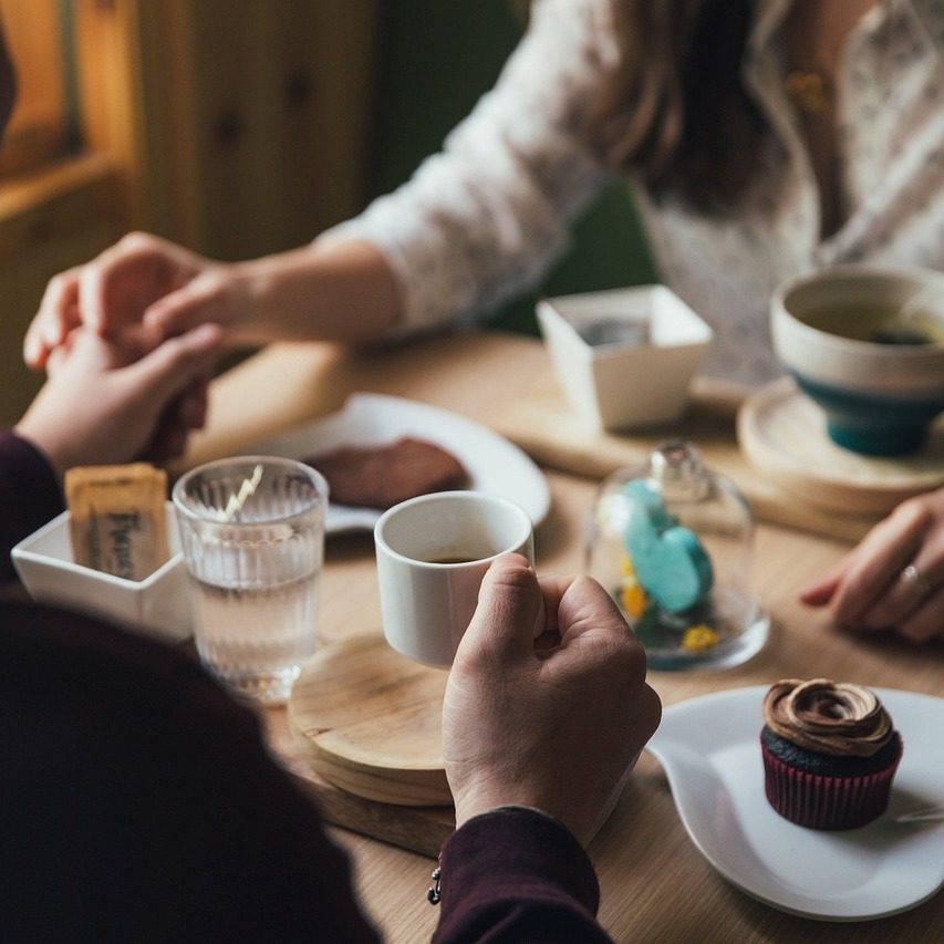 Vendégek beszélgetnek kávé mellett